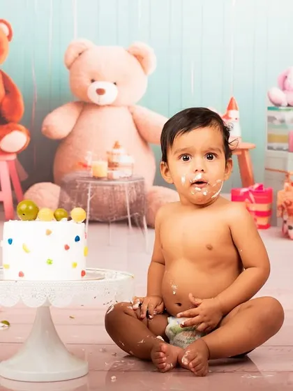 The aftermath of a fun cake smash. This portrait captures the baby's surprised and happy expression, covered in frosting.