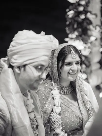 A quiet, smiling moment between the couple during their ceremony, captured in timeless black and white.