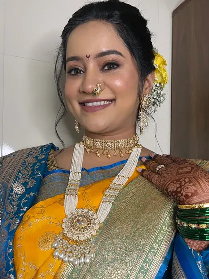 A close-up of the bride's jewellery and makeup. The long pearl necklace and choker are classic choices for a Maharashtrian bride.