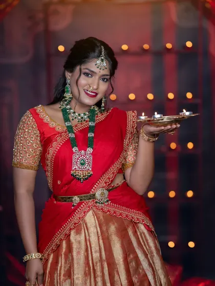 This model is wearing a stunning emerald and polki haara, a perfect statement piece for a bridesmaid in a half-saree.