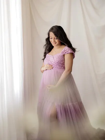 A serene and gentle portrait. The soft focus and dreamy lighting create a timeless image, capturing the quiet beauty of pregnancy.