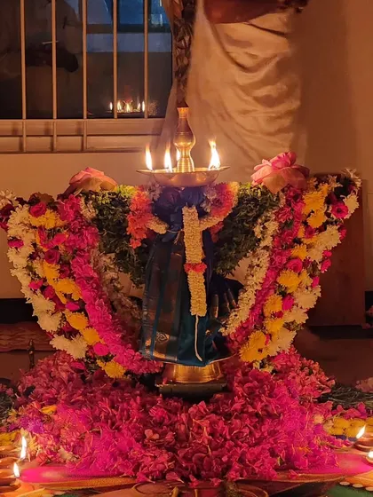 A kalasha decorated to represent the Goddess, placed on a bed of flowers.