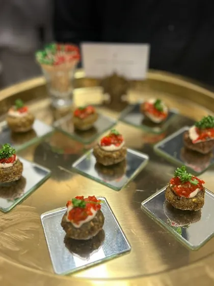 Mushroom and truffle bites served on individual mirrored plates. This appetizer is a rich and earthy option for cocktail parties, presented elegantly on a golden tray.