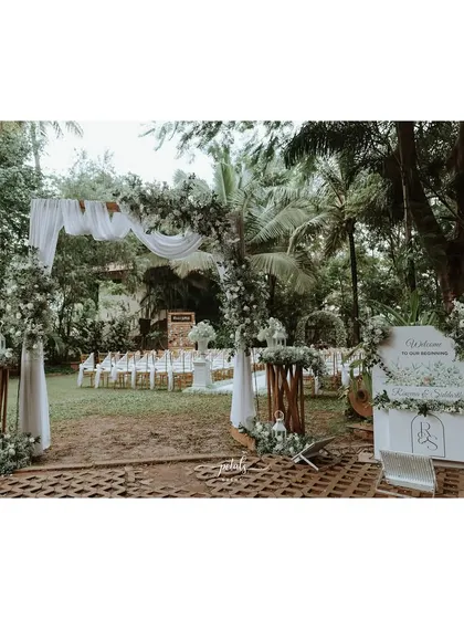 A beautiful entrance arch and welcome board, decorated with white flowers and greenery, sets a graceful and welcoming tone for the wedding.
