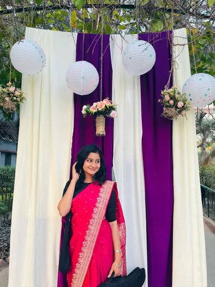In a bright pink saree with my instrument case at a college fest. I'm always ready for the stage, whether it's a modern gig or a traditional one.