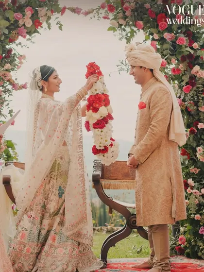 The varmala exchange under a stunning floral arch in Tuscany, a key moment from the wedding featured in Vogue India.