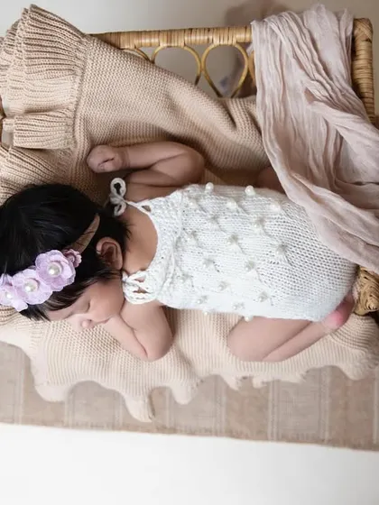 An overhead view shows the beautiful details of the setup, with the newborn nestled in a basket, surrounded by soft fabrics. I carefully style each session to be unique.