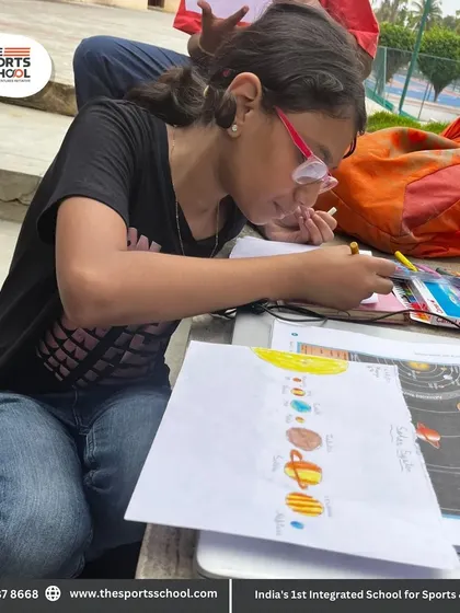 A student proudly displays her drawing of the solar system, completed during an outdoor class where nature and science meet.