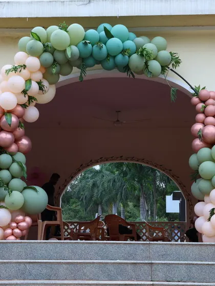 This is a full view of a modern balloon arch at the top of a staircase, creating a grand entrance. The matte pastel balloons provide a contemporary and stylish look.