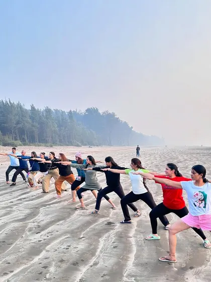 The warrior line-up. Students practicing Virabhadrasana (Warrior Pose) on the beach during our yoga retreat.