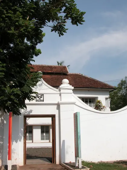 The entrance gate to the restored 1740 Dutch house in Fort Kochi. The clean white walls and the historic curved pediment signal the building's heritage, a project of careful conservation and adaptation.