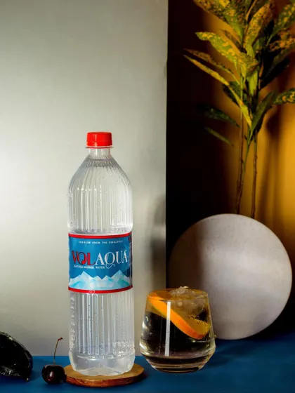 A modern still life featuring a bottle of Volaqua water. The use of geometric shapes, contrasting colors, and dramatic lighting creates a contemporary and stylish product photograph.