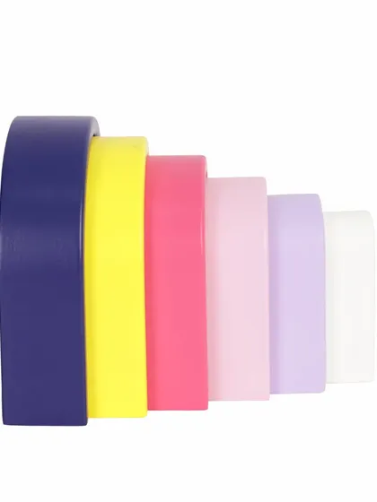 A side view of a nested wooden pastel arch toy, showing the gradient of colors.