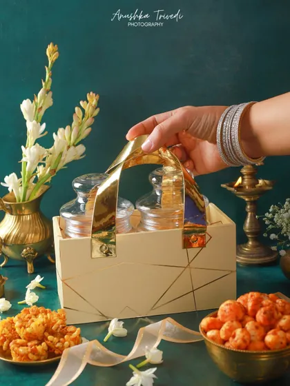 A still life shot of the elegant jar hamper, styled with traditional Indian decor against a rich teal background.
