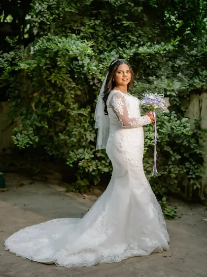 A full-length portrait of the beautiful bride. Her mermaid-style gown is perfectly complemented by her soft, flowing waves and natural, glowing makeup.