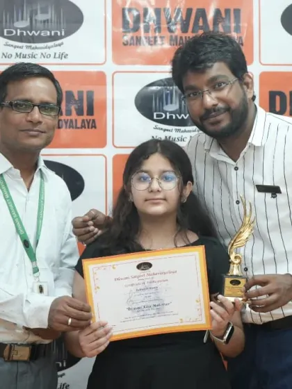 Teachers from our drums and keyboard departments with a proud student and her award.