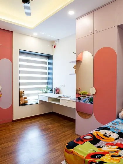 A wider shot of the pink and lavender kids' room, showcasing the dual beds, shared desk space, and whimsical Mickey Mouse bedding that adds a touch of fun.
