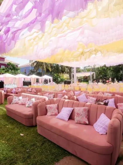 The comfortable and stylish pink lounge sofas arranged for guests at the outdoor Mehendi.