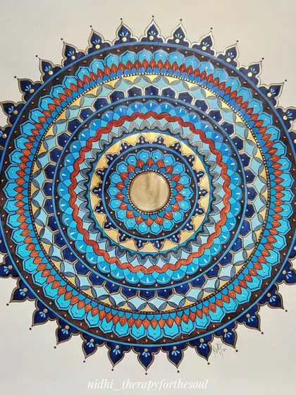 A custom 60x60cm mandala with a blue and brown color scheme. The cool blues and warm, earthy tones create a beautiful contrast in this intricate piece.