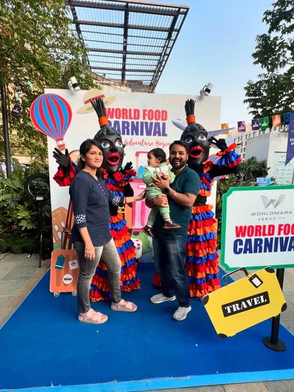 A family poses for a photo with costumed performers at the World Food Carnival. This image shows the fun and family-friendly atmosphere of my events.