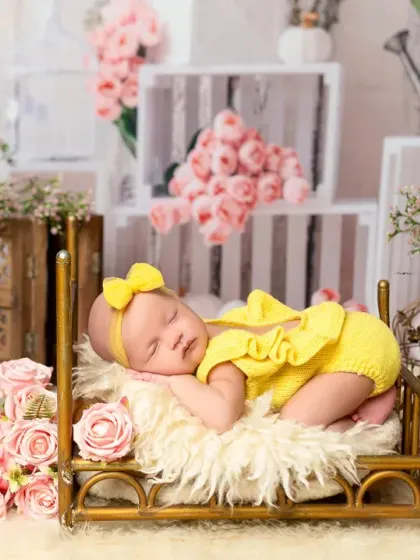 A wider shot of the yellow-themed newborn session, showcasing the beautiful floral and rustic props that create a charming and complete scene.