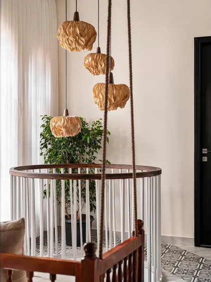 A close-up of the unique paper-mache pendant lights hanging above the spiral staircase, adding a sculptural and organic element to the space.