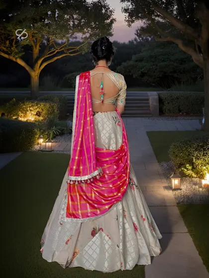 Elegance is stitched into every patch. The back of this printed lehenga shows the intricate patchwork and a vibrant pink dupatta, perfect for any festive celebration.