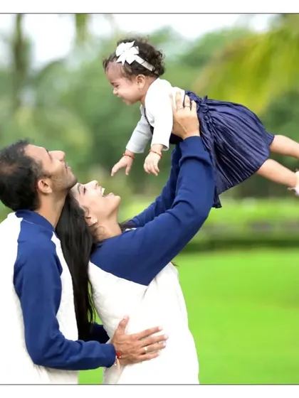 A playful and heartwarming moment between parents and their daughter. Lifting the child up creates a dynamic and joyful photo that is full of love and energy.