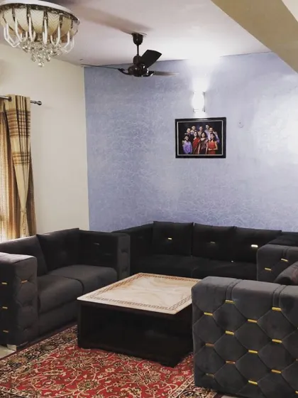 Here is one of my custom sofa sets in a client's home. The dark grey upholstery with quilted side detailing and gold accents fits perfectly within their living room, showing how a tailored piece can elevate the entire space.
