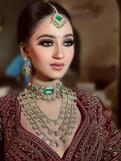 Seamlessly merging elegance with royalty. This look features intense smokey eyes and is paired with stunning emerald jewelry for a truly regal effect.