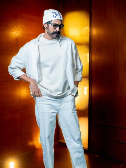 The monochrome white allows the focus to be on the different textures and layers of the outfit.