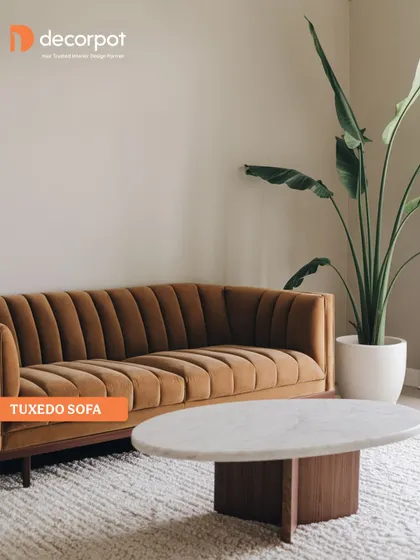 The Tuxedo sofa, characterized by its high arms that are the same height as the back, offers a sleek and modern silhouette. Its channel-tufted design adds a touch of retro glamour to this living room.