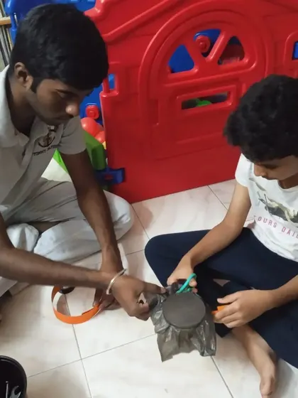 An instructor helps a student construct a tonoscope to visualize sound waves.