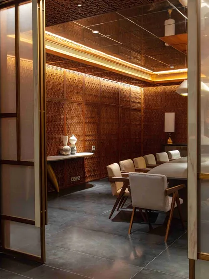 A view into the dining room through the doorway, framed by Sanjhi art screens. This perspective highlights the layered experience we create as one moves through the home.