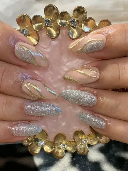 A sophisticated mix of silver glitter and gold wave accents on a neutral base.
