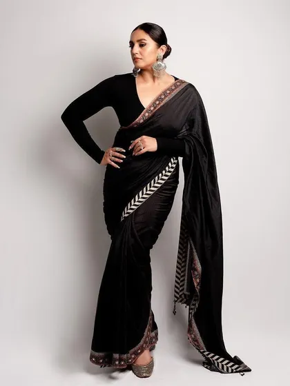 The full silhouette of the black JJ Valaya saree. It's a masterclass in modern Indian dressing, combining tradition with a bold, graphic border and a minimalist blouse.