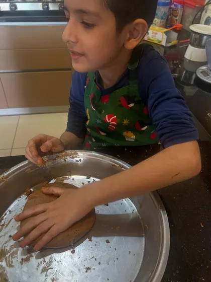 A moment of concentration while kneading. These hands-on life skills activities are just as important as academic learning in my homeschooling approach.