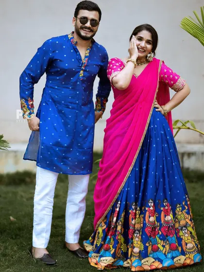 A coordinated couple's look, with the bride in a royal blue and pink half saree and the groom in a matching blue kurta.
