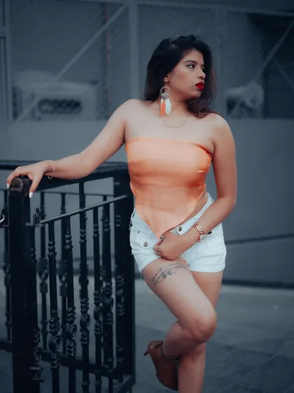 A portrait of a model leaning against a railing, with a cool and moody color grade. This shot is perfect for a sophisticated urban fashion portfolio.