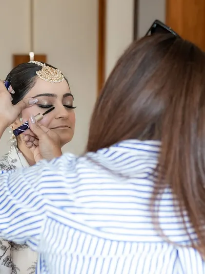 This is me in my element. A behind-the-scenes shot of me applying mascara to a bride, showcasing the focus and gentle touch I bring to every single client to ensure they feel comfortable and look perfect.