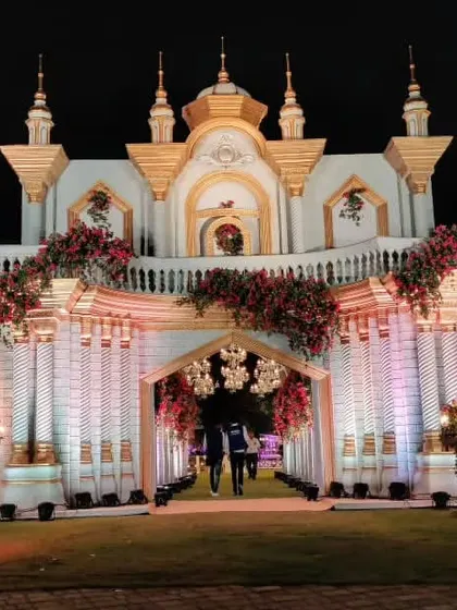 A straight-on view of the grand palace entrance, with a couple silhouetted in the doorway, illustrating the scale and fairytale quality of the design.