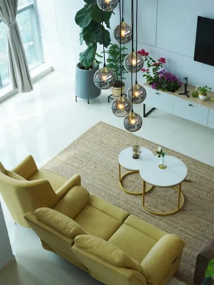 Another angle of the penthouse, showcasing the interplay of light and space. The strategic placement of furniture and the dramatic chandelier draw the eye upwards, emphasizing the room's impressive scale.