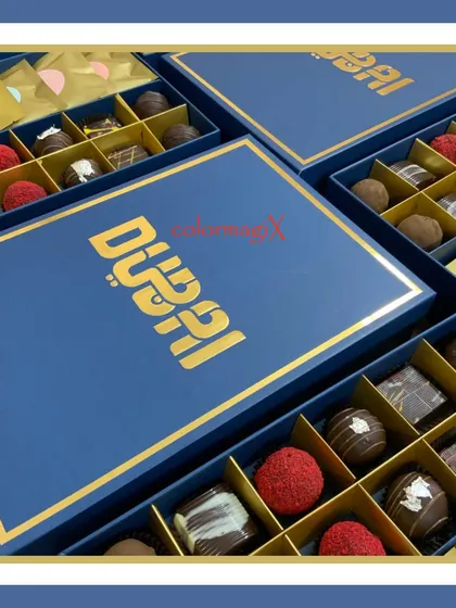 A close-up of the custom "Dubai" branded chocolate boxes. Each box is filled with an assortment of premium, handcrafted chocolates, making it a luxurious and impressive corporate gift.