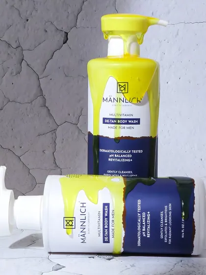 A creative and edgy shot with yellow paint dripping over the men's body wash bottles. This abstract approach is designed to be scroll stopping and memorable for a bold, modern brand.