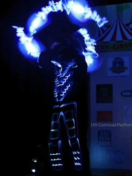 Igniting the stage with every spin. A Tron performer creates a halo of blue light with pixel poi, demonstrating the fusion of tech and art.