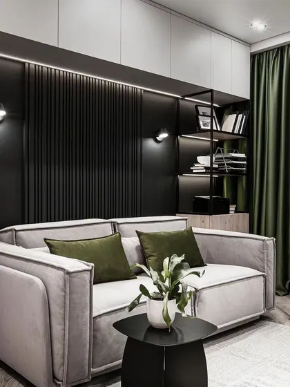 A compact living space or study nook with a two-seater sofa, set against a dark, fluted wall with built-in shelving. This design is a great example of creating a functional and stylish small area.