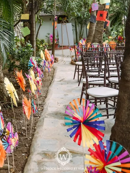 A pathway lined with colorful, handcrafted pinwheels and kites for a carnival-themed Mehendi. These playful details created a whimsical entrance for guests.