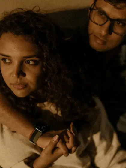 A close-up, intimate portrait of a couple at night. The focus is on their connection and the quiet moment they share.