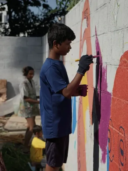 This student from the Project Defy mural workshop is completely in the zone, adding color to the wall. It is incredible to witness how art can create such a strong sense of purpose and concentration.