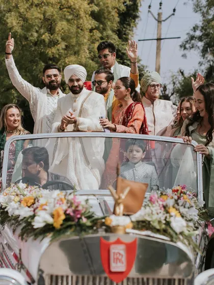The baraat arriving in style in a vintage car, decorated with fresh flowers, ready for a grand wedding celebration.